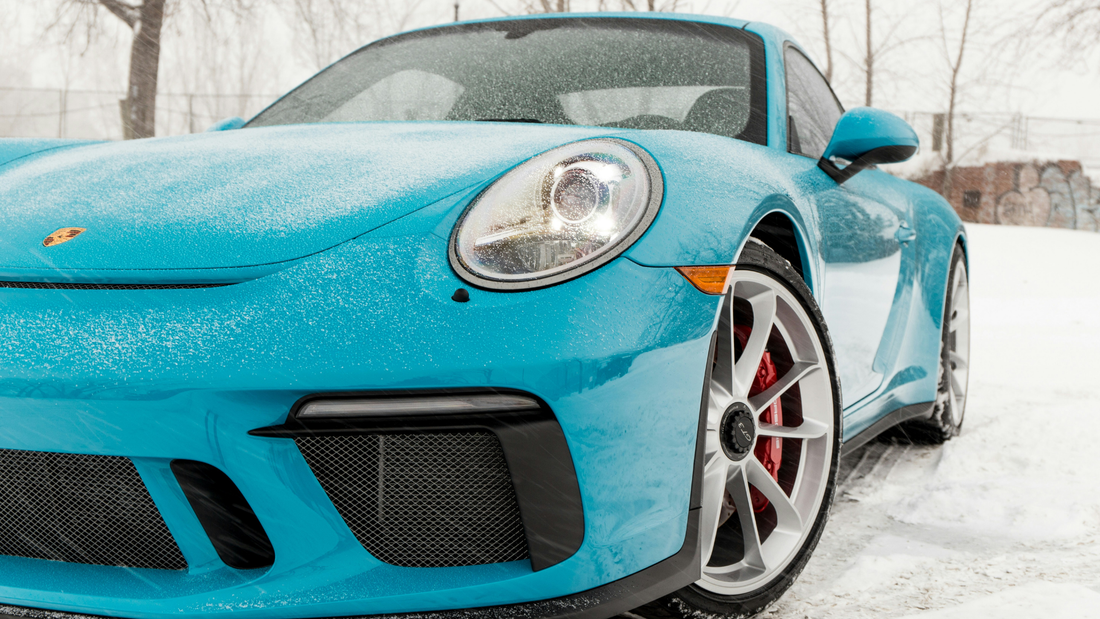 Blue Porsche in the snow with the headline “Ceramic Coating vs. Wax: Which is better for Canadian winters?”
