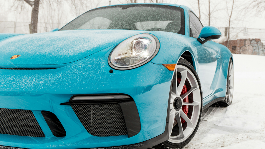 Blue Porsche in the snow with the headline “Ceramic Coating vs. Wax: Which is better for Canadian winters?”